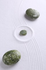Zen concept. Stones and pattern on white sand