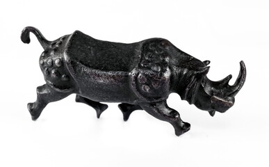 A purchased (consumer) figurine of a rhinoceros made of cast iron in close-up on a white background