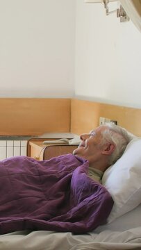 Female doctor helps ederly patient in hospital. Vertical Video