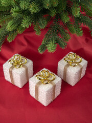 New Year's still life, three gifts under the tree on a red background