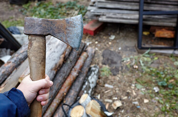 Man holding axe. Ax in hand. A strong man holds an ax in his hands against the background of...