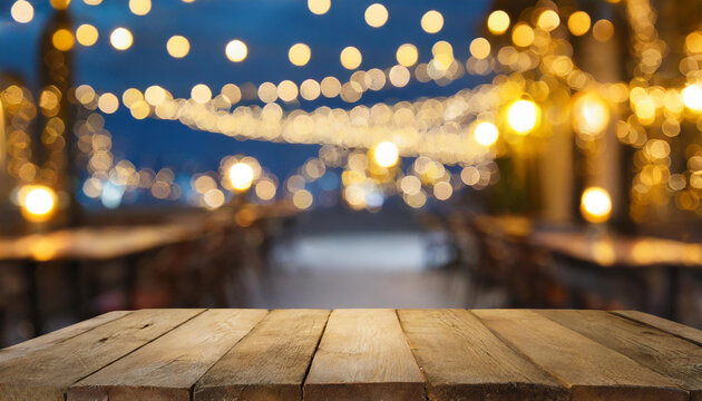 Picture of a wooden table against a background of vaguely blurred restaurant lights