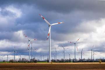 Symbolbild: Windpark in Ostdeutschland.  Mehrere Reihen von Windrädern auf einer landwirtschaftlichen Fläche.