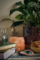 Still life - books, Himalayan salt lamps and potted plant