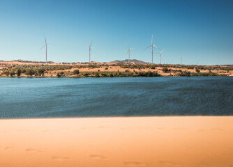 Wind turbines, sand dunes and a large lake