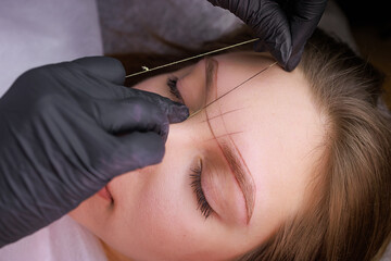 Marking eyebrows with thread before the procedure of permanent makeup. PMU Procedure, Permanent...