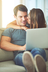 Kiss, computer and woman hugging man on sofa networking on social media, website or internet. Happy, love and female person embracing husband reading online blog with laptop in living room at home.