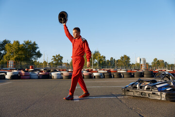 Sportsman celebrating end of go-cart racing at outdoor driveway