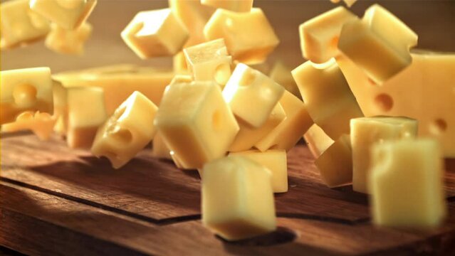 Super slow motion pieces of cheese fall onto a cutting board. Filmed on a high-speed camera at 1000 fps. High quality FullHD footage