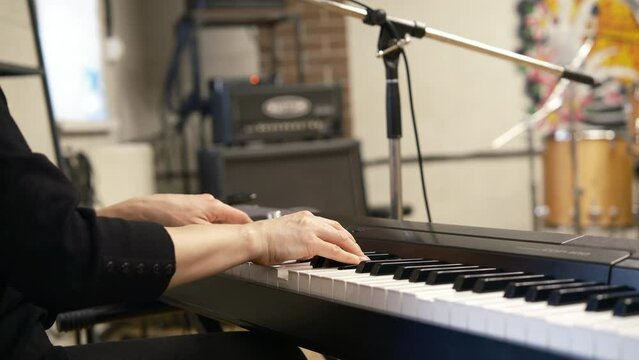 Close up vocal lesson. The teacher's hands do the work on the synthesizer and guide. interior classroom
4k