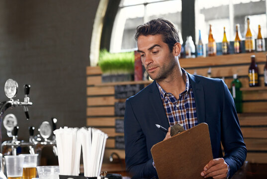 Bar, stock or man with checklist for small business logistics, inventory or menu update on clipboard. Startup, reading pub info or manager writing sale price for an order in diner cafe or restaurant