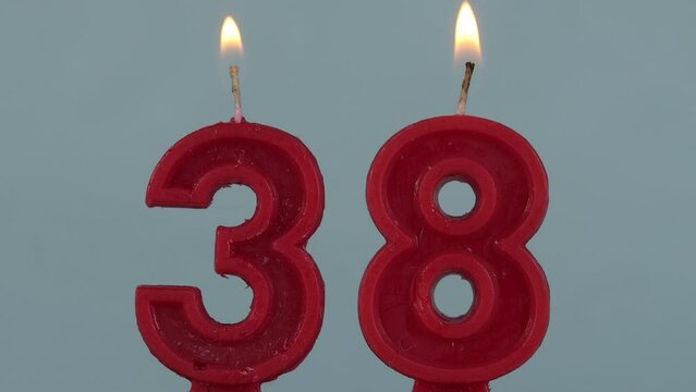 close up on a red number thirthy eighth birthday candle on a white background.
