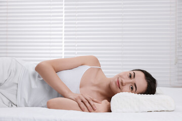 Obraz premium Woman lying on orthopedic pillow at home