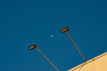street lamp on blue sky with moon background