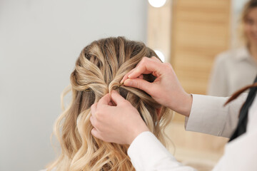 Naklejka premium Hair styling. Professional hairdresser working with client in salon, closeup
