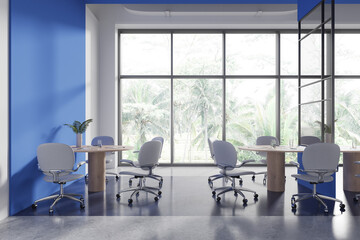 Stylish office coworking interior with work table and seats, panoramic window