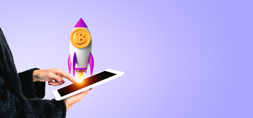 Woman finger touch tablet, rocket with bitcoin on copy space background