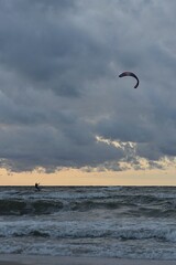 Kiteboarding. A man plays sports on the sea waves