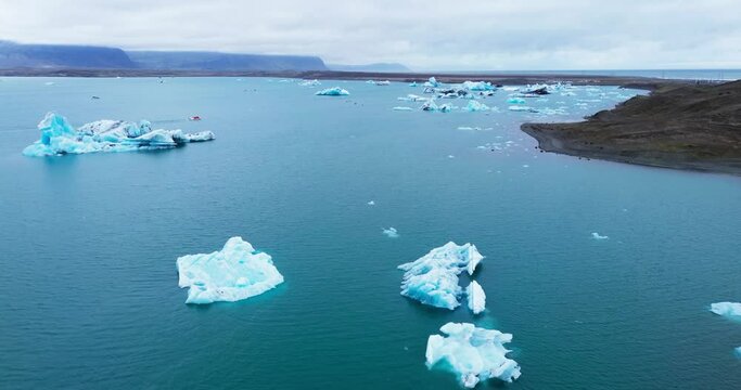 Icebergs from melting glacier in Jokulsarlon lagoon in Iceland, Arctic nature ice landscape in Unesco World Heritage Site, Drone aerial video top view - Climate Change and Global Warming.