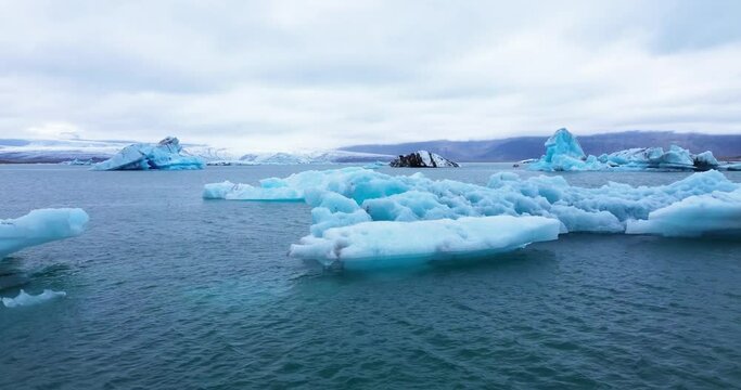 Icebergs from melting glacier in Jokulsarlon lagoon in Iceland, Arctic nature ice landscape in Unesco World Heritage Site, Drone aerial video top view - Climate Change and Global Warming.