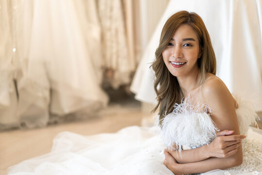 Portrait Of Smiling Cheerful Beautiful Pretty Asian Fashion Bride Woman Posing With Make-up And Hairstyle In White Wedding Dress At Wedding Interior Fashion Studio