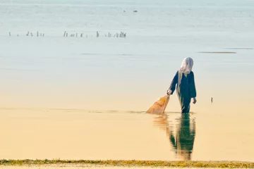 Abwaschbare Fototapete Zanzibar Fisherman on mudflat in Zanzibar