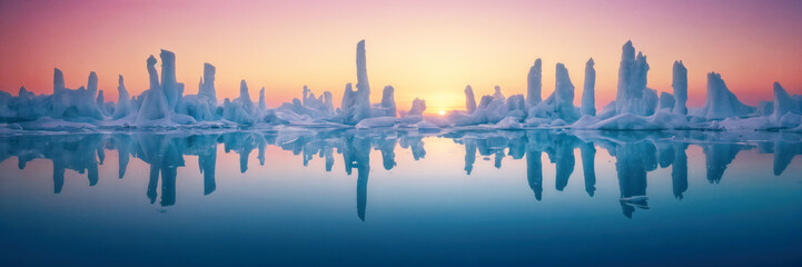 Fototapeta premium mesmerizing sight of ice sculptures gracefully floating in the water, illuminated by the warm hues of the sunset