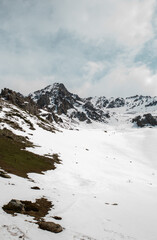 Snow-capped mountain peaks and rocks in the distance with snow-covered hills in the foreground