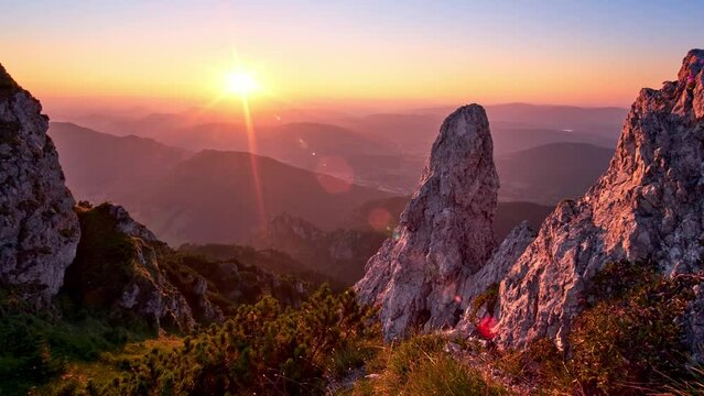 Sunset in a hilly summer landscape, rocks and rhombus illuminated by the setting sun, cloudless sky