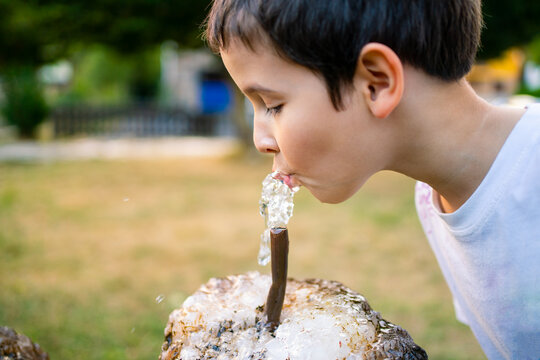 Child drinking water from a fountain on the park