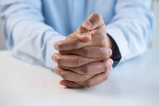 Cropped shot of hands of nervous, anxious and worried man fidget with finger feeling stress, uncertain and overwhelmed while waiting for job interview. Fingers of worker