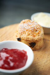 A beautiful gourmet scone served with tea and coffee, strawberry jam and clotted cream. traditional british food. Cackes and see treats
