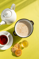 Warm and Inviting Breakfast Scene with Oatmeal, Tea, and Honey on Yellow Background
