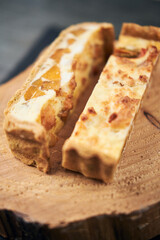 A beautiful delicious gourmet organic tomato and pumpkin quiche served on a rustic slate plate. Rustic fine dining lunch menu halloween fall season.