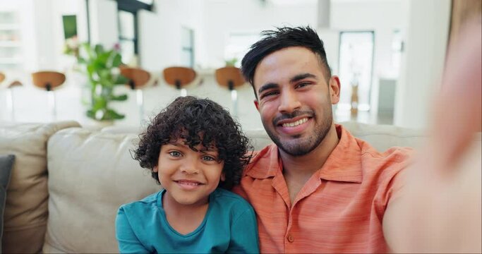 Selfie, smile and face of father and child on a sofa for bonding and relaxing together at home. Happy, love and young Indian dad taking a picture with boy kid in the living room of modern house.