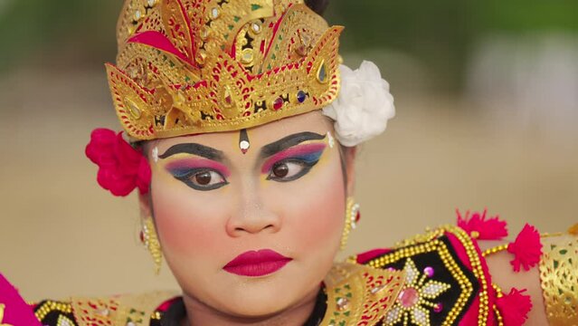 Slow motion close up of young balinese dancer looking at camera, facial expression