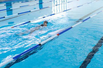 A swimmer practices in a pool, with copy space