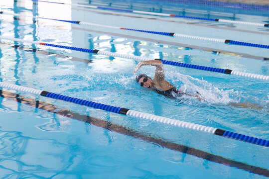 Caucasian female athlete swimmer swimming laps in a pool
