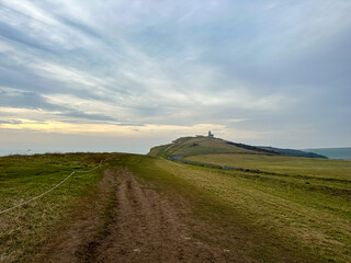 Fototapeta premium Eastbourne, England, UK. Belle Tout Lighthouse view from Seven Sisters cliffs in East Sussex. Cliff walking path view from Beachy Head to Birling Gap in Southern England.