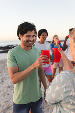 Diverse friends enjoy a beach party at sunset