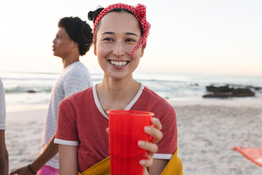 Young biracial woman smiles at the beach, with copy space