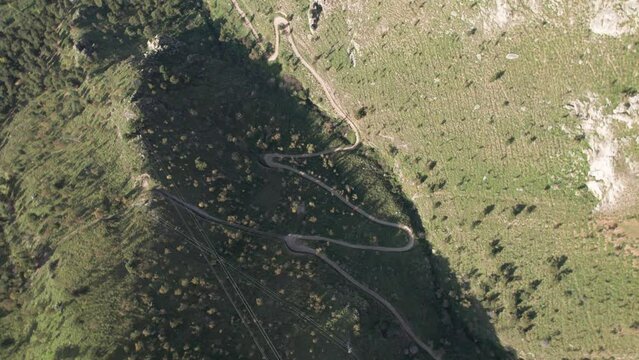 Aerial view drone of mountain road. Sunny day. Going down rotating