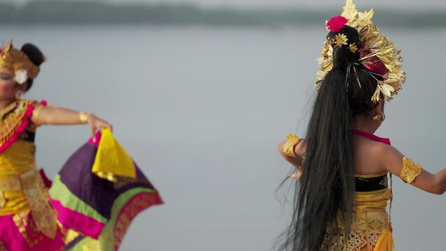 Dramatic slow motion shot of two balinese dancers dancing in bali, southeast asia