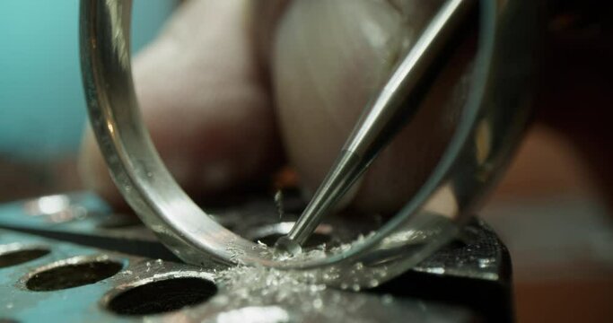 Crop jeweler making hole in ring