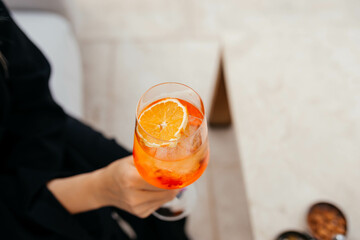person holding a glass of Aperol Spritz