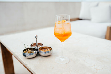 Aperol Spritz on the table with nuts 