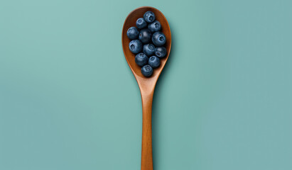 Blueberries Food on a spoon: Succulent blueberries on a rustic wooden spoon, teal background.