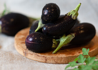 Assortment raw organic of purple vegetables mini eggplants, spring onion, beetroot, radicchio salad, plums, kohlrabi, flower salt over dark metal background. Top view with space. Food frame