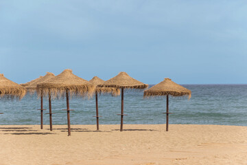 natural grass umbrella on empty beach with blue ocean