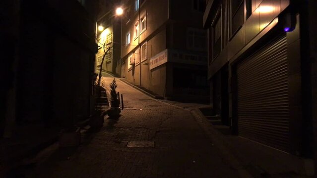 Walking uphill at night on a dimly lit cobblestone street in Istanbul Turkey.
